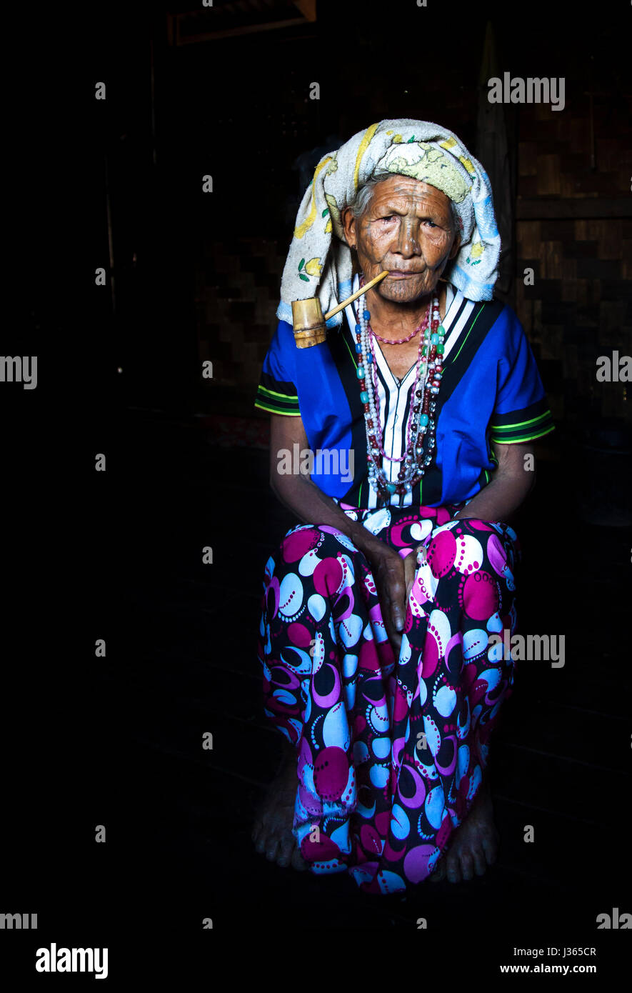 Kinnbereich, Myanmar, 11. November 2014: Muun Stamm Kinn Dame in ihrer Küche, ihre Pfeife rauchen Stockfoto