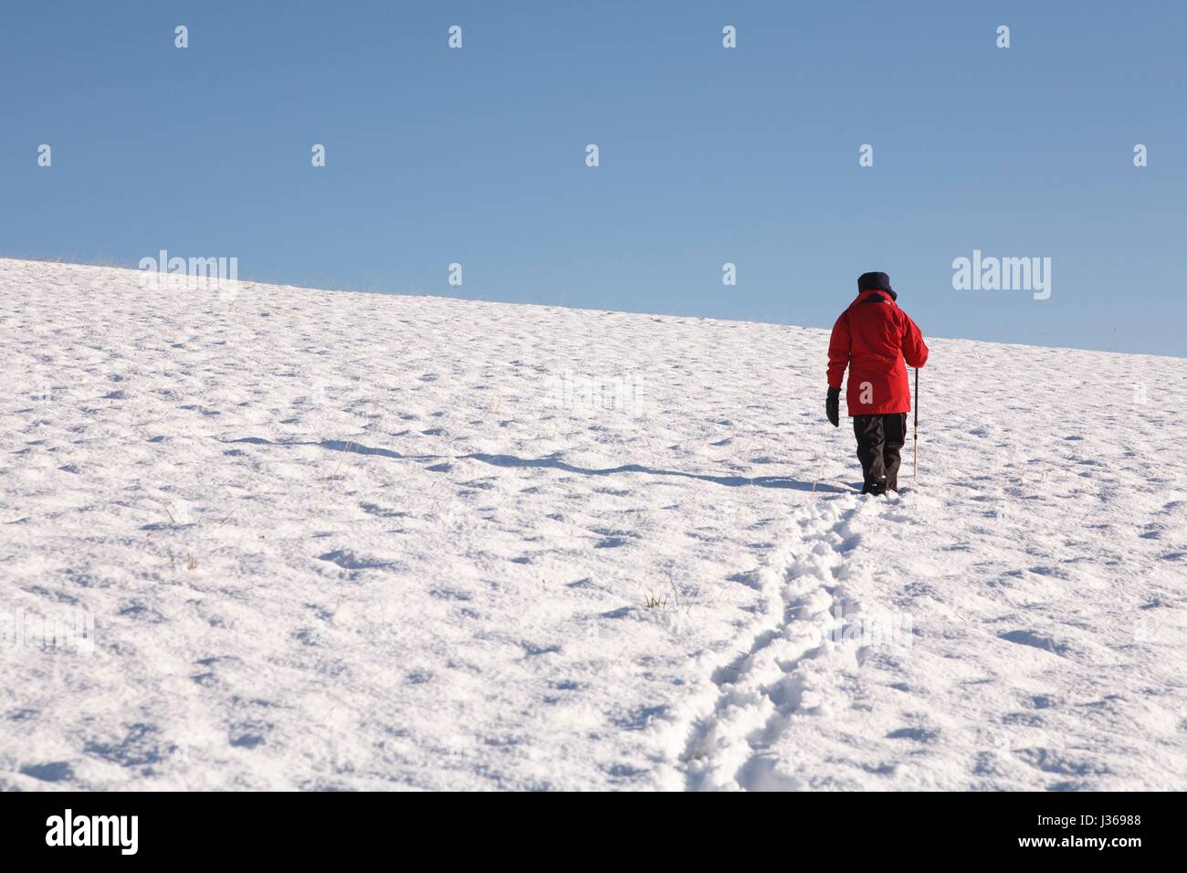 Frau allein zu Fuß bergauf bedeckt Schnee im winter Stockfoto