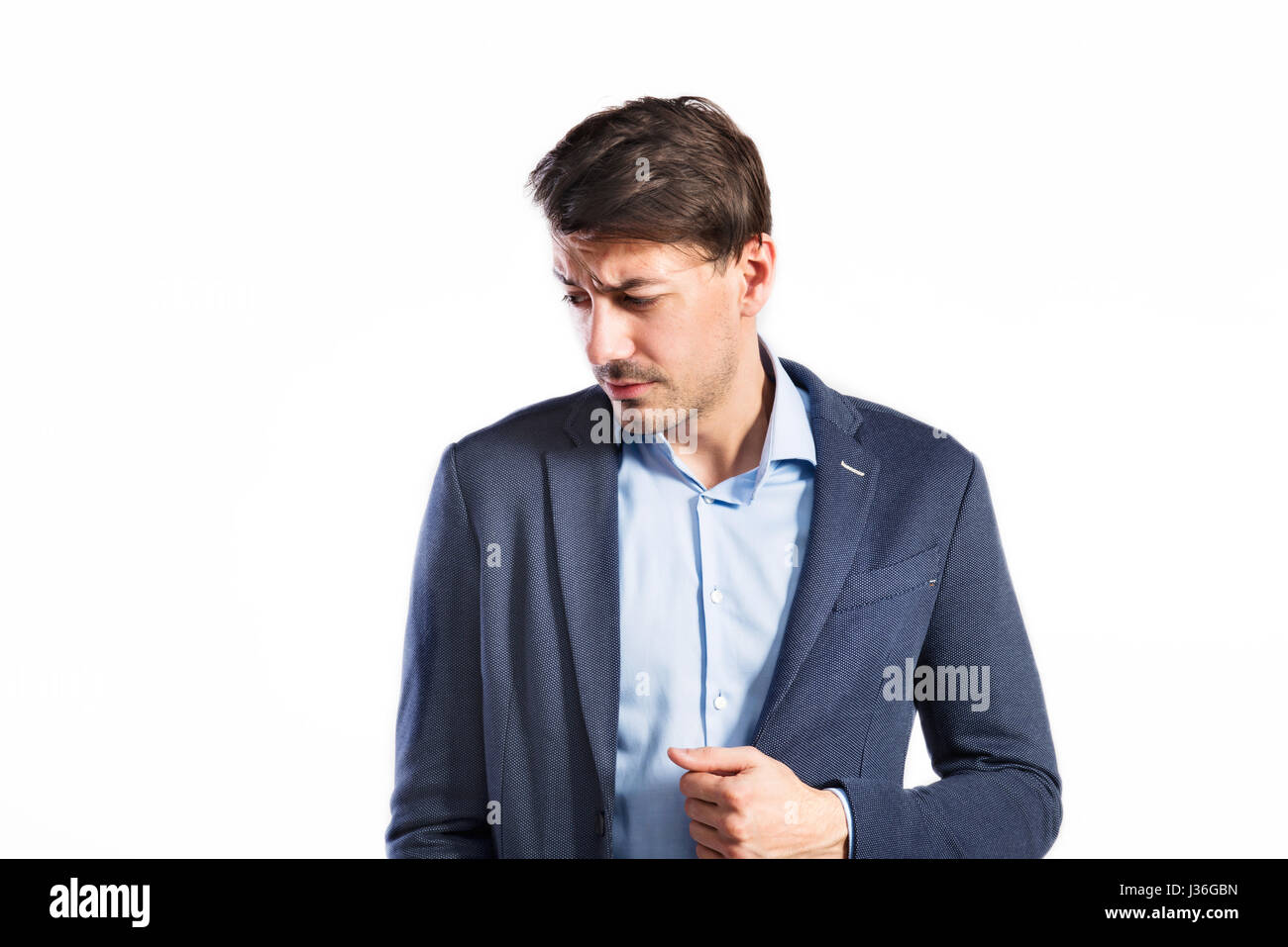 Hübscher junger Mann im blauen Jacke. Studioaufnahme, isoliert. Stockfoto