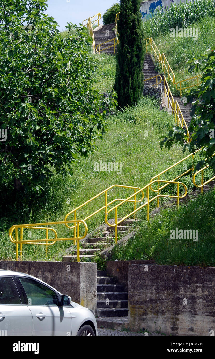 Eine lange Treppe, in vier langen Flügen, die Verknüpfung der sozialen Wohnungsbau Komplex zu einer Hauptstraße mit Bussen in der campolide Viertel von Lissabon, Portugal Stockfoto