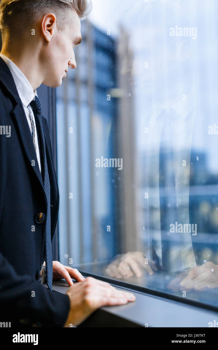 Porträt eines jungen Mitarbeiters Fenster stand Stockfoto