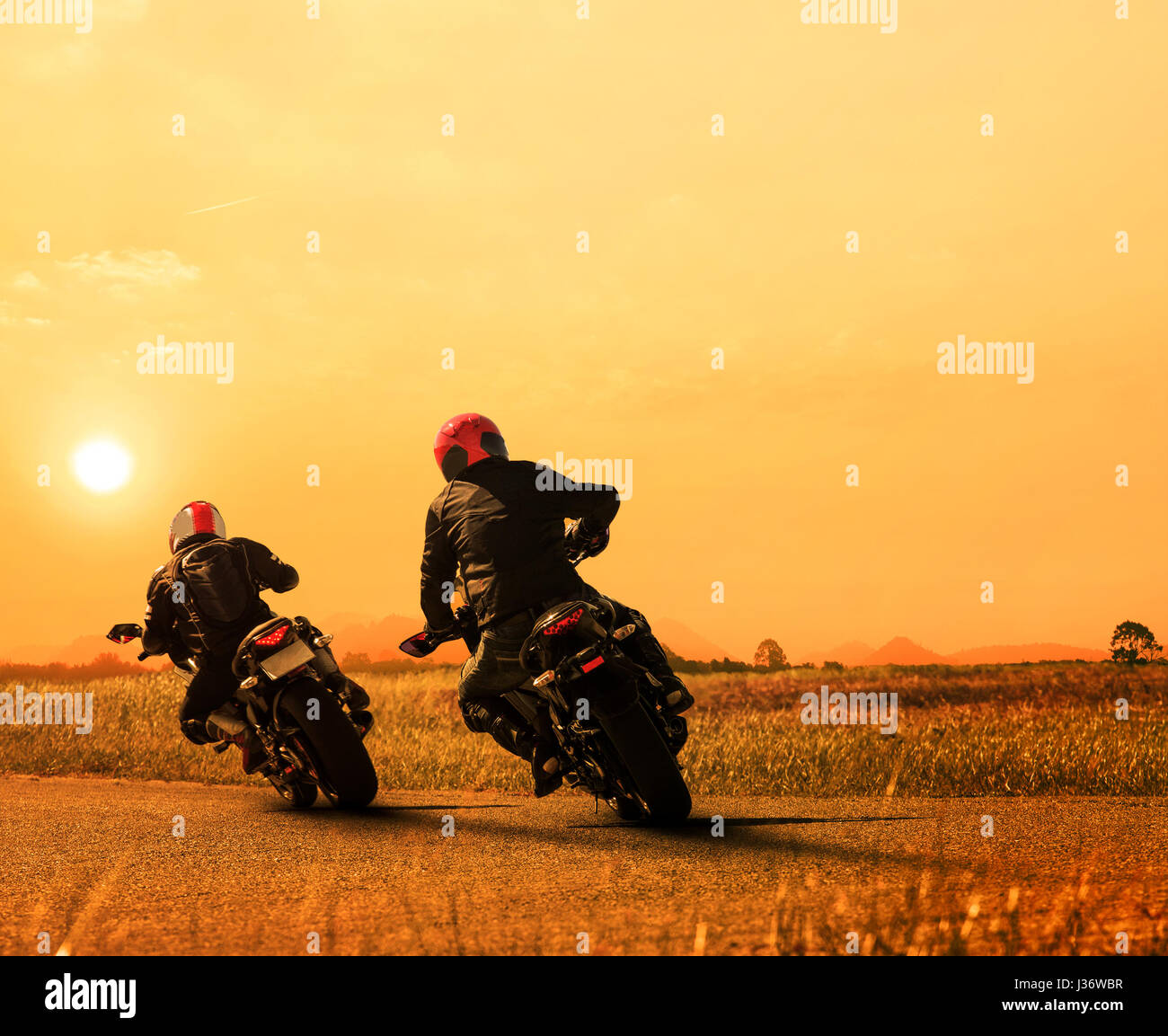 Paare Freund Motorradfahrer Radfahren auf Asphalt Autobahn gegen die schöne Sonne setzen Himmel Einsatz für Mensch und Mensch Freizeitaktivitäten im Motorsport und tr Stockfoto