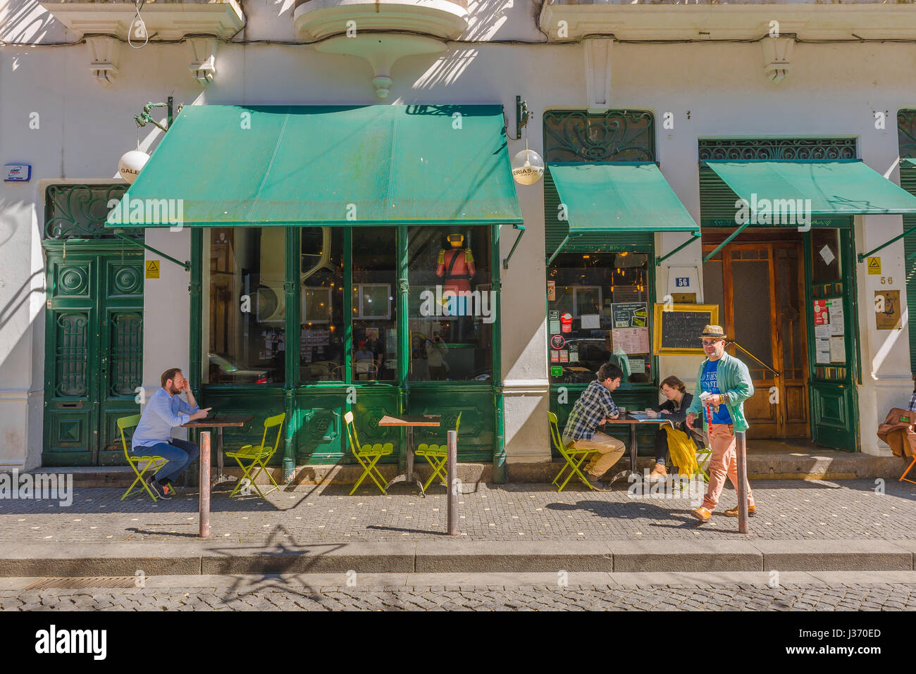 Cafe Portugal, Blick im Sommer von Menschen sitzen an Tischen außerhalb einer Café-Bar in einer ruhigen Straße in der historischen Altstadt von Porto, Portugal. Stockfoto