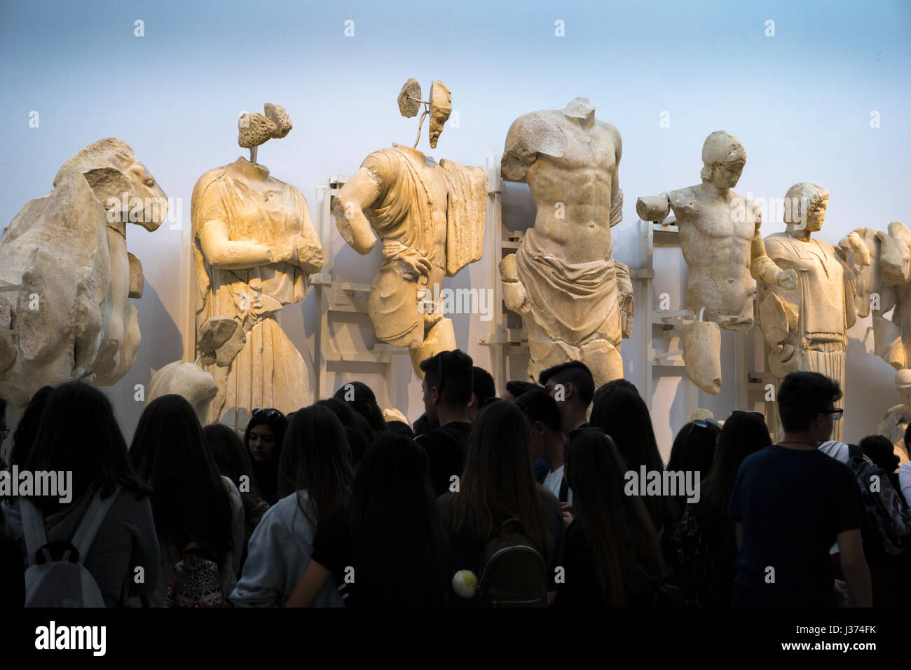 "Die Götter herabsehen", Touristen, die Skulpturen aus der Ostgiebel des Zeustempels anzeigen. Archäologisches Museum, das antike Olympia, Peloponnes, Stockfoto