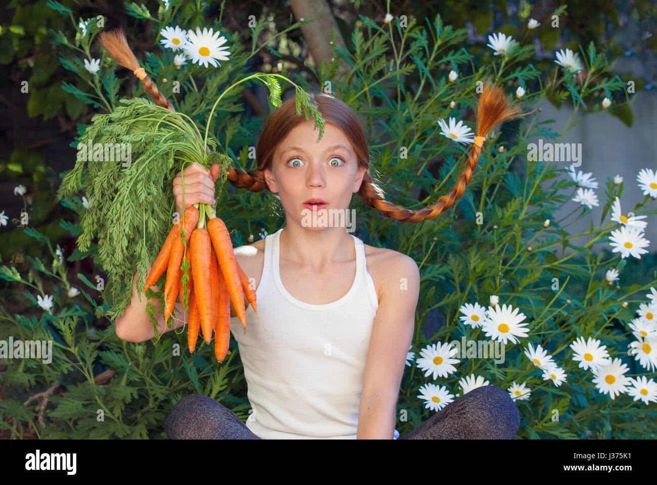 gesundes Kind mit Gemüse Karotten in der Natur. Stockfoto