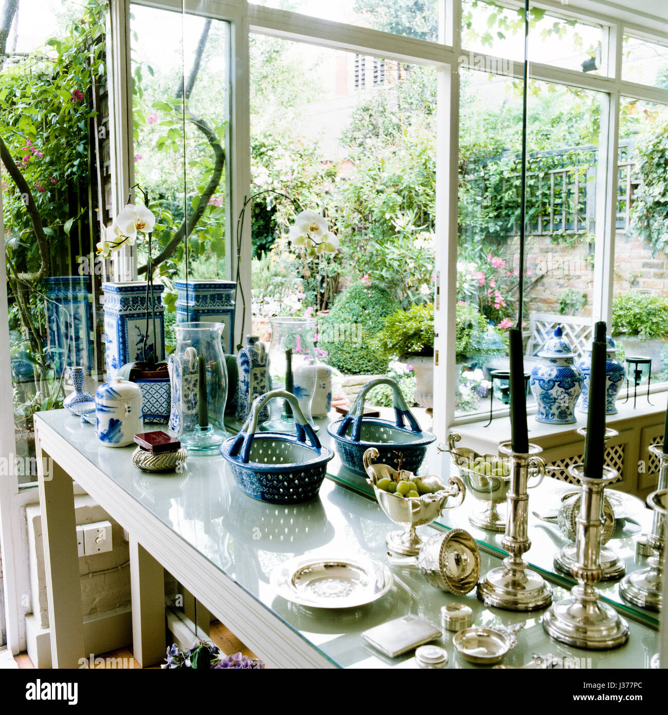 Sortierte Antiquitäten auf Tisch im Wintergarten. Stockfoto