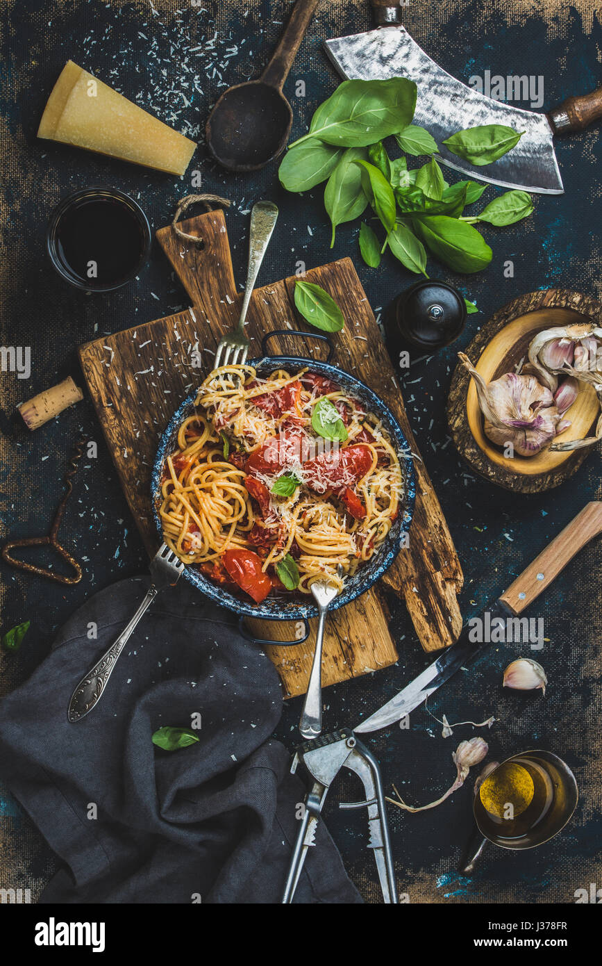 Spaghetti mit Tomaten und Basilikum und Zutaten für die Herstellung von Teigwaren Stockfoto