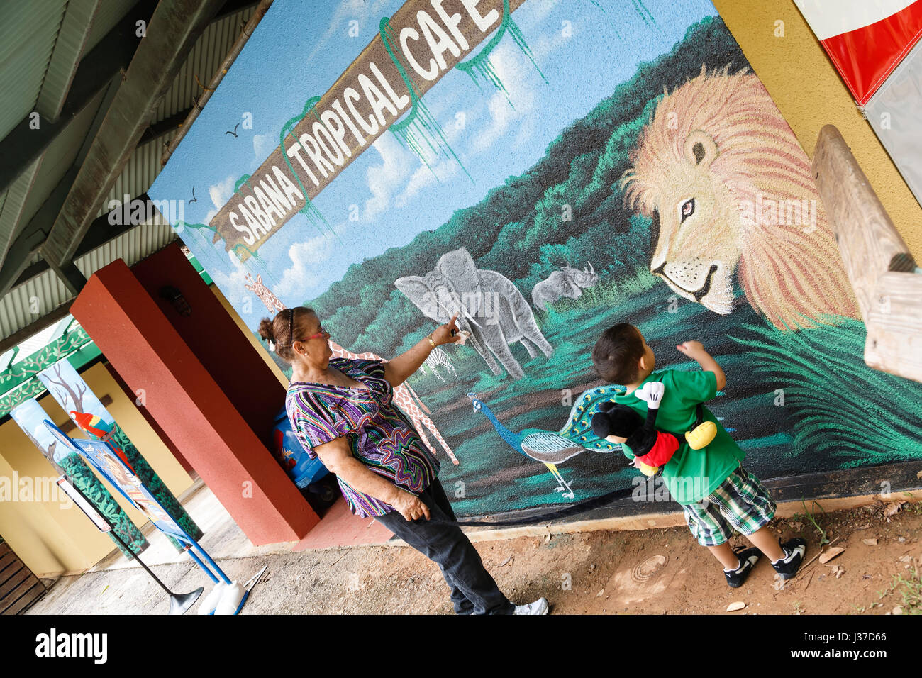 Frau und Junge an der Wandgemälde von Sabana Tropical Cafe, Mayaguez Zoo (Juan A. Rivero), Puerto Rico Stockfoto