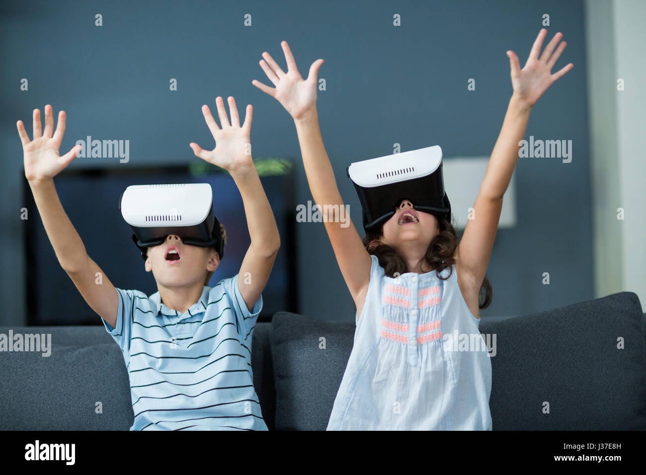 Geschwister mit virtual-Reality-Kopfhörer im Wohnzimmer zu Hause Stockfoto