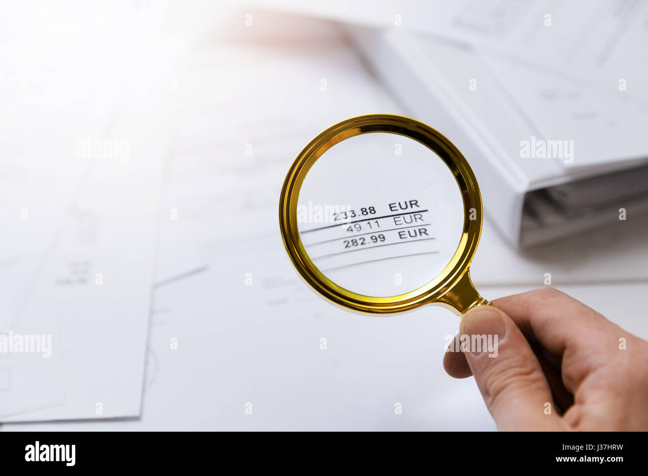 Audit-Konzept - Prüfer prüfen Rechnungen mit Lupe Stockfoto