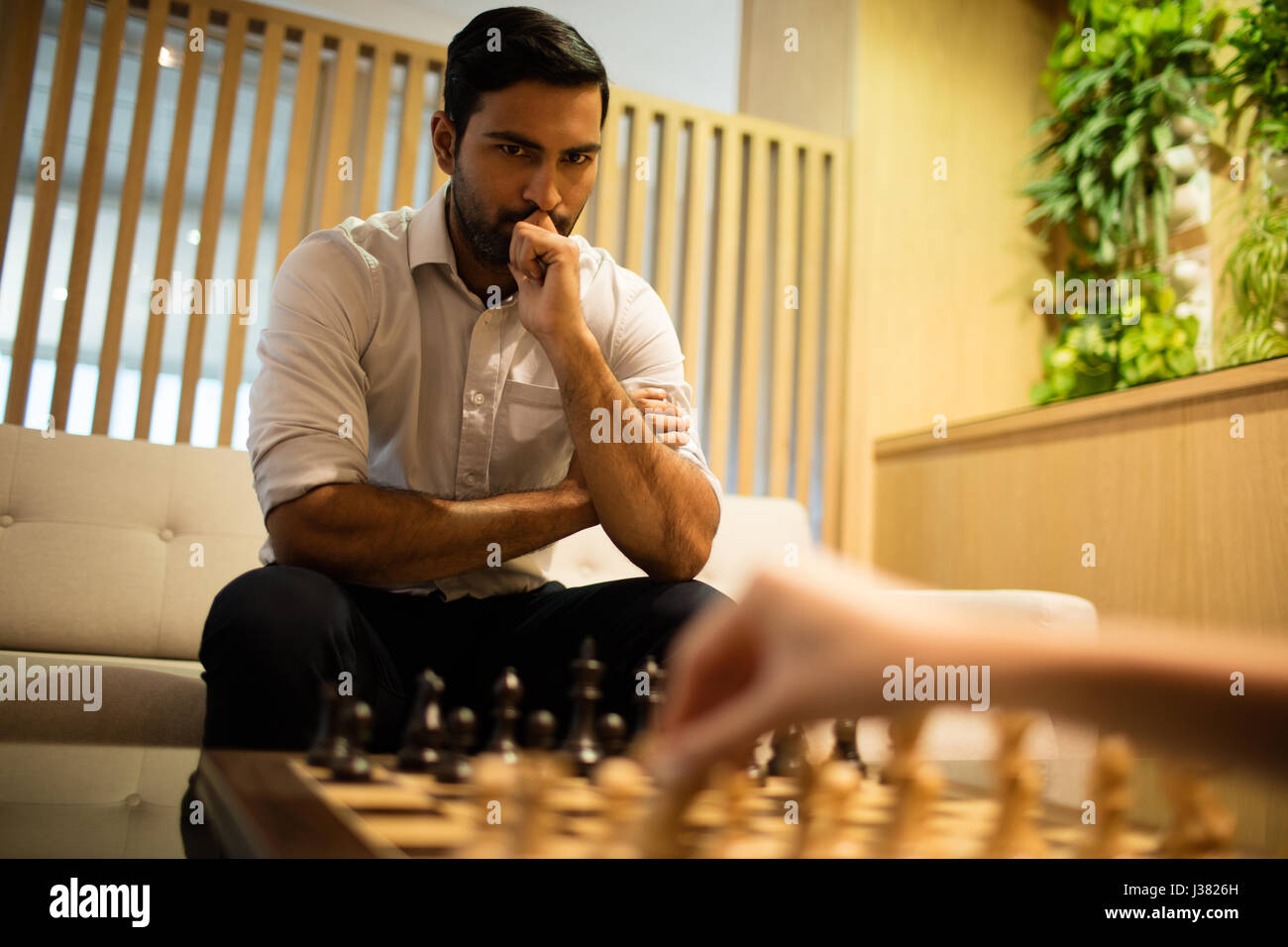 Nachdenklich Geschäftsmann Schachspiel mit Kollegin im Büro Stockfoto
