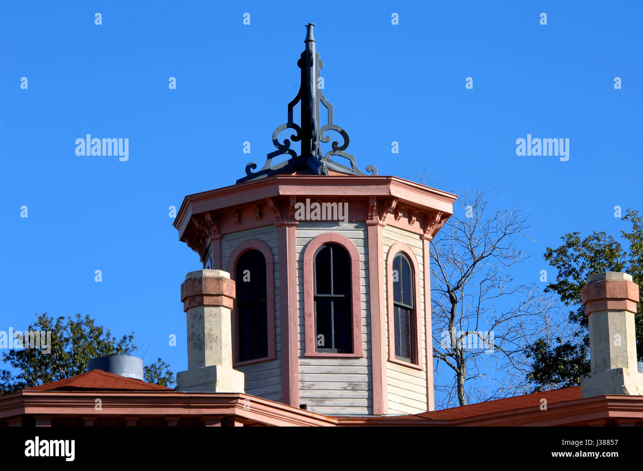 Eleganten viktorianischen Dachlinie umfasst Achteck geformt mit bemalten trim und gewölbten Fenstern.  Top gehören schwarze kunstvolle Dekoration. Stockfoto