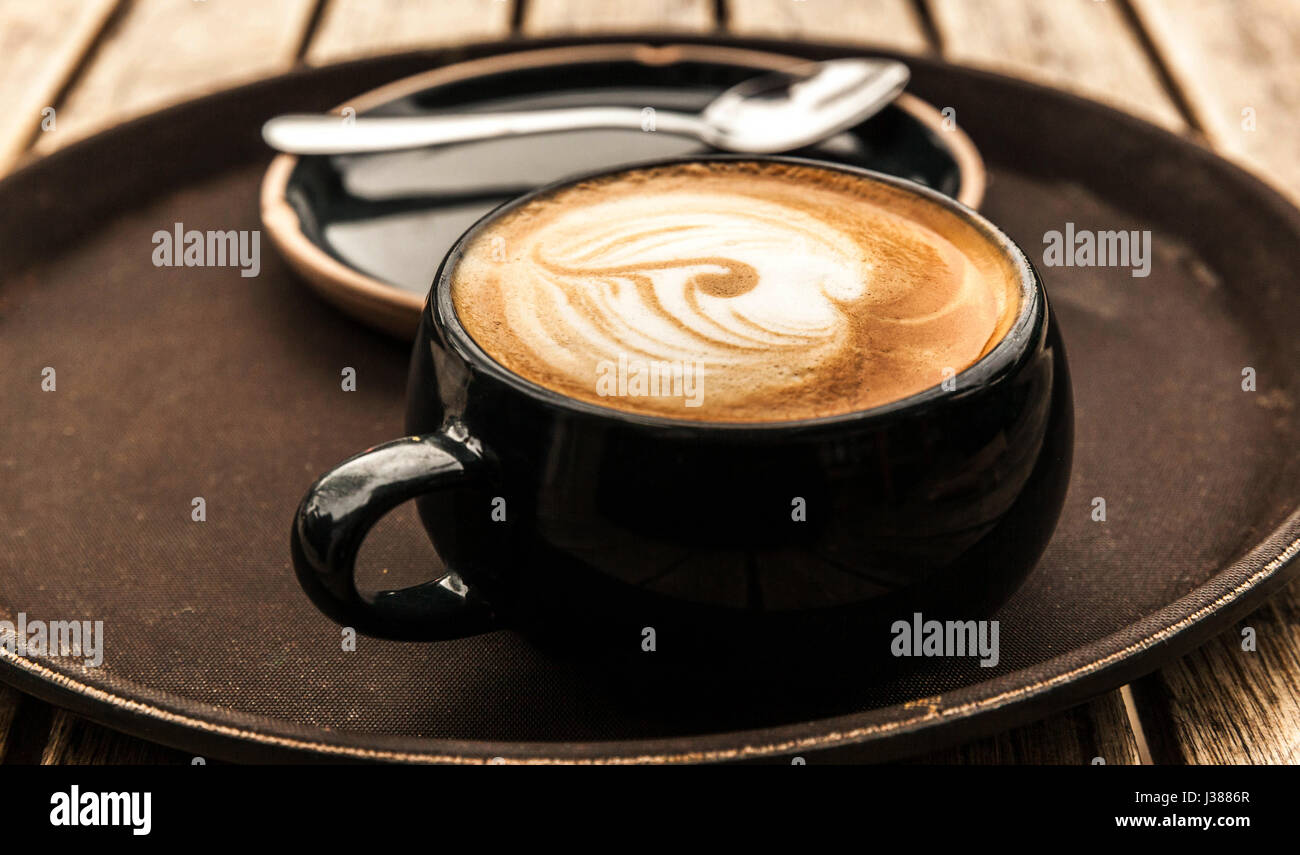 Tasse Latte Kaffee auf einem runden Tablett Stockfoto