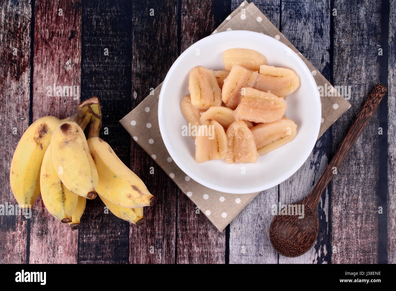 Thai beliebtes Dessert, fertig gekochte Banane in Sirup serviert und Löcher Banane serviert auf Holz. Stockfoto