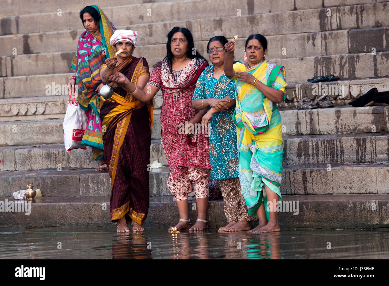 Frau Anzünden von Kerzen in einem Ritual auf dem Ufer des Ganges in Varanasi, Indien Stockfoto