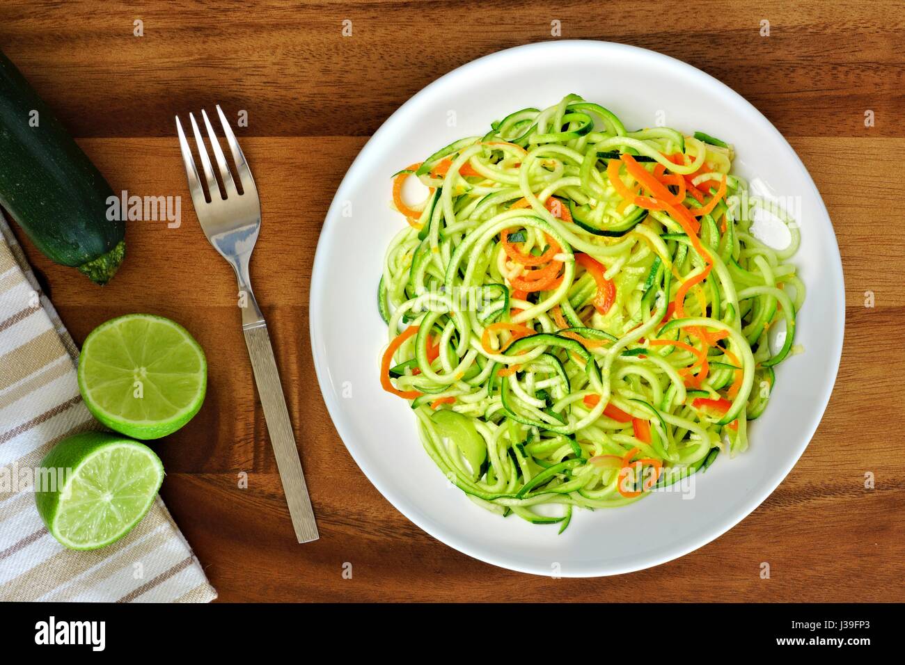Gesunde Zucchini Nudel-Gericht mit Karotten und Kalk auf Holz Hintergrund, Draufsicht Stockfoto