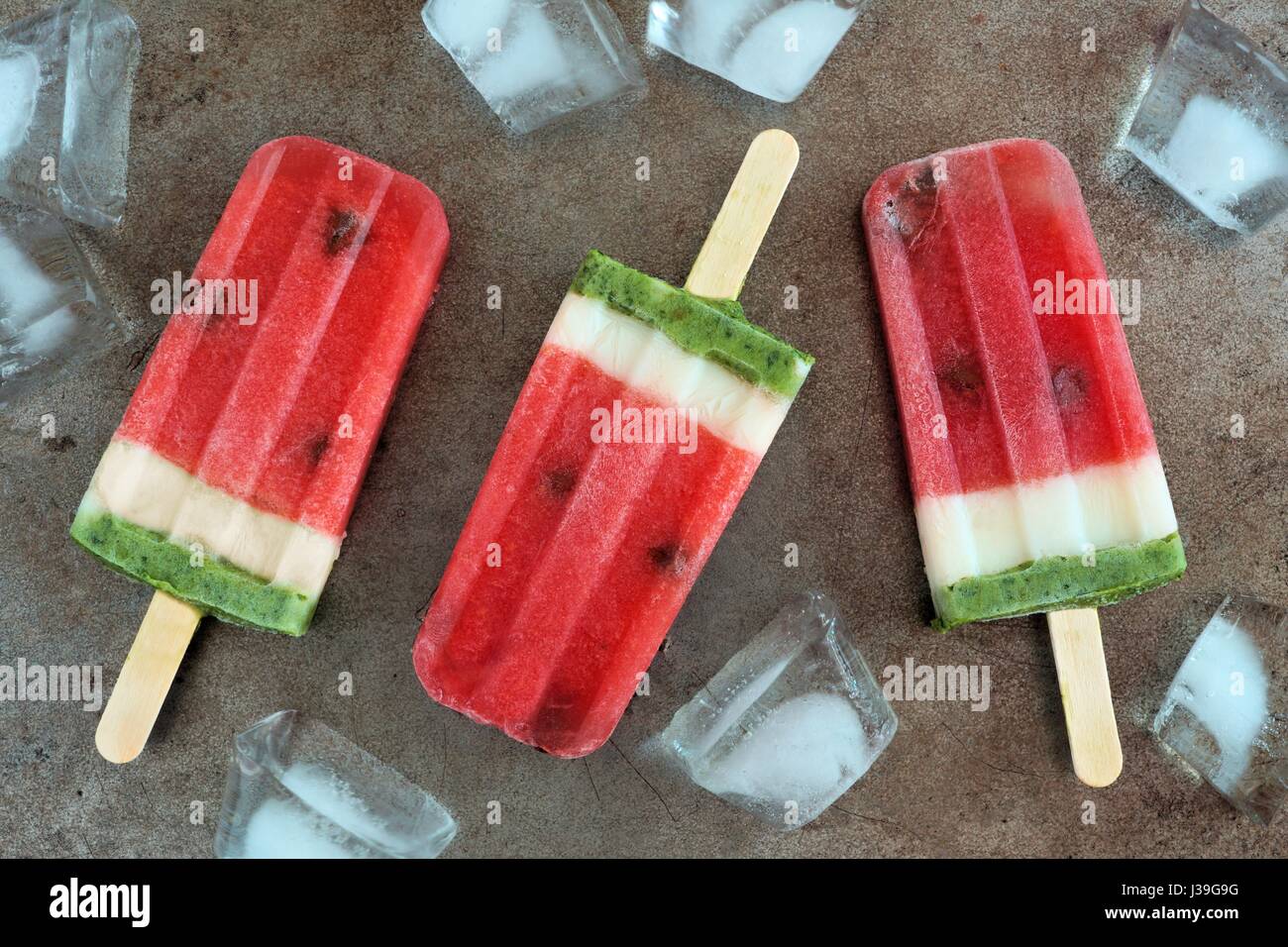 Hausgemachte Wassermelone Eis am Stiel mit Eis auf einem Vintage Metalltablett Hintergrund Stockfoto