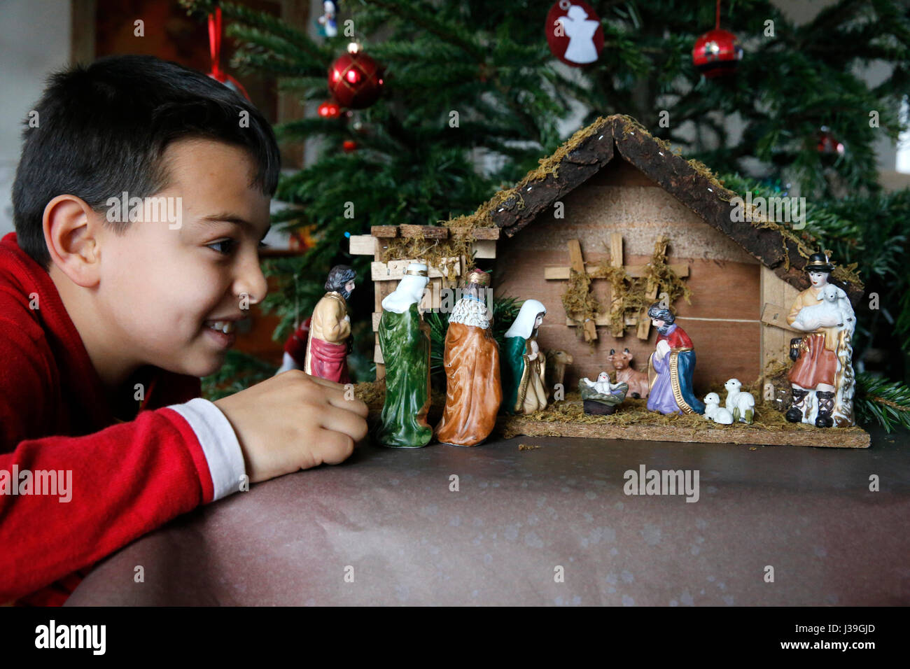 10-Year-Old Boy Verlegung eine Weihnachtskrippe. Stockfoto