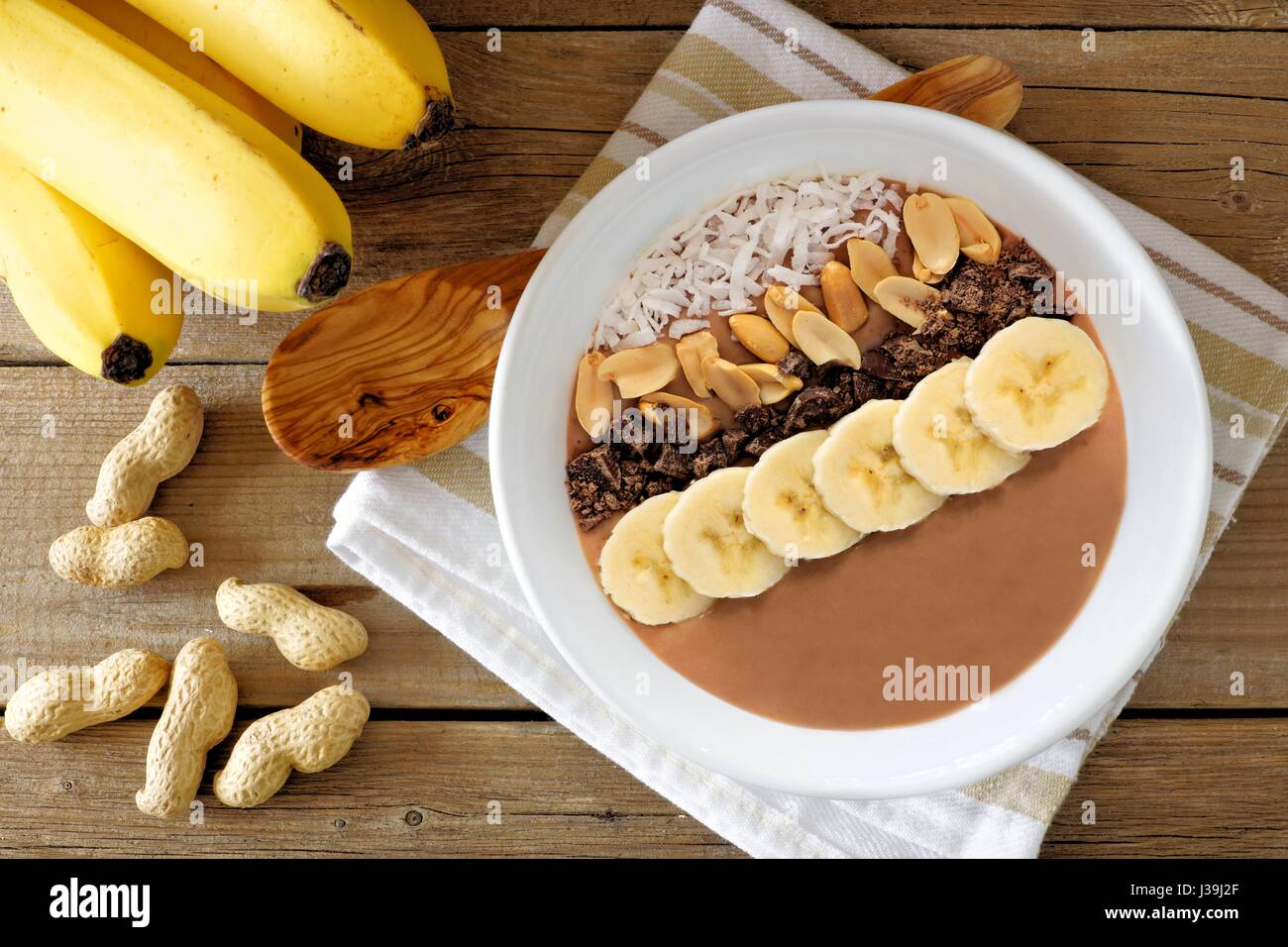 Schokolade Erdnussbutter Banane Smoothie Schüssel Overhead Szene auf rustikalen Holz Hintergrund Stockfoto