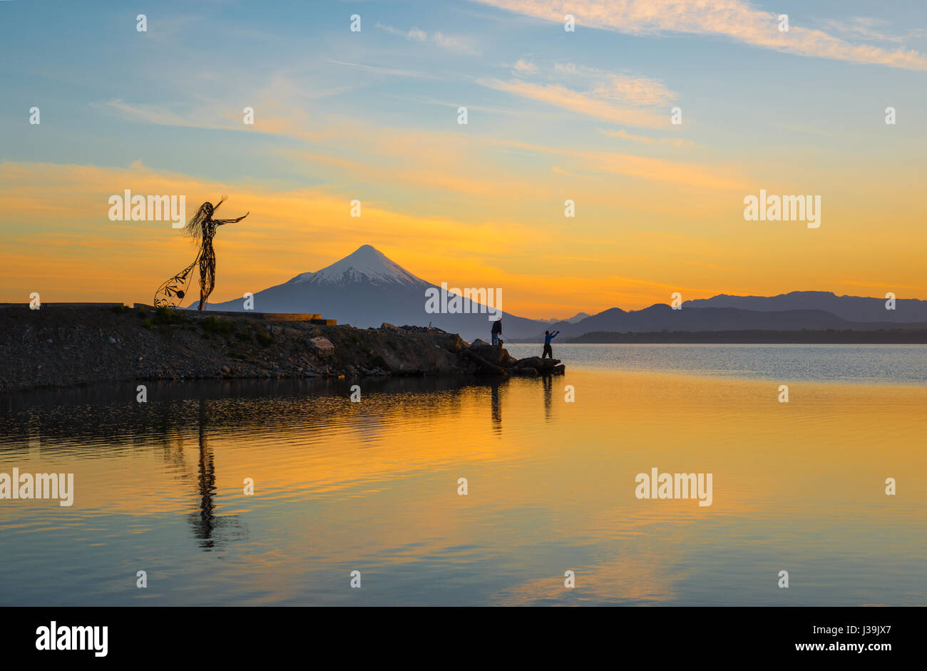 Zwei Fischer am Llanquihue-See bei Sonnenaufgang mit den Osorno Vulkan in der Nähe von Puerto Montt im Seengebiet von Chile von Puerto Varas aus gesehen. Stockfoto