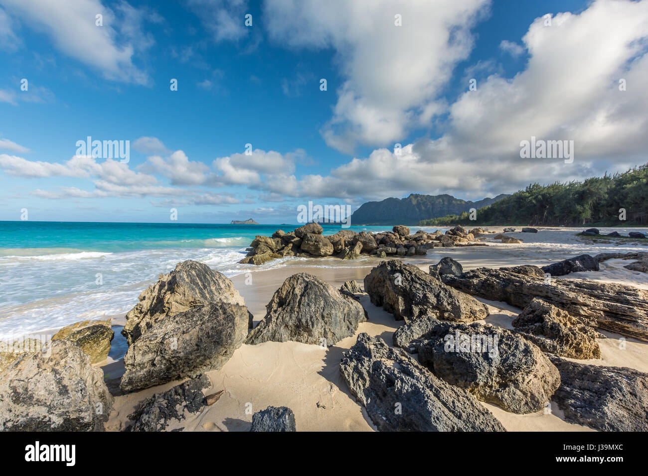 Große Felsen und schönen smaragdgrünen Waimanalo an einem sonnigen Tag auf der Insel von Oahu, Hawaii, die Wälder und Berge sichtbar. Stockfoto