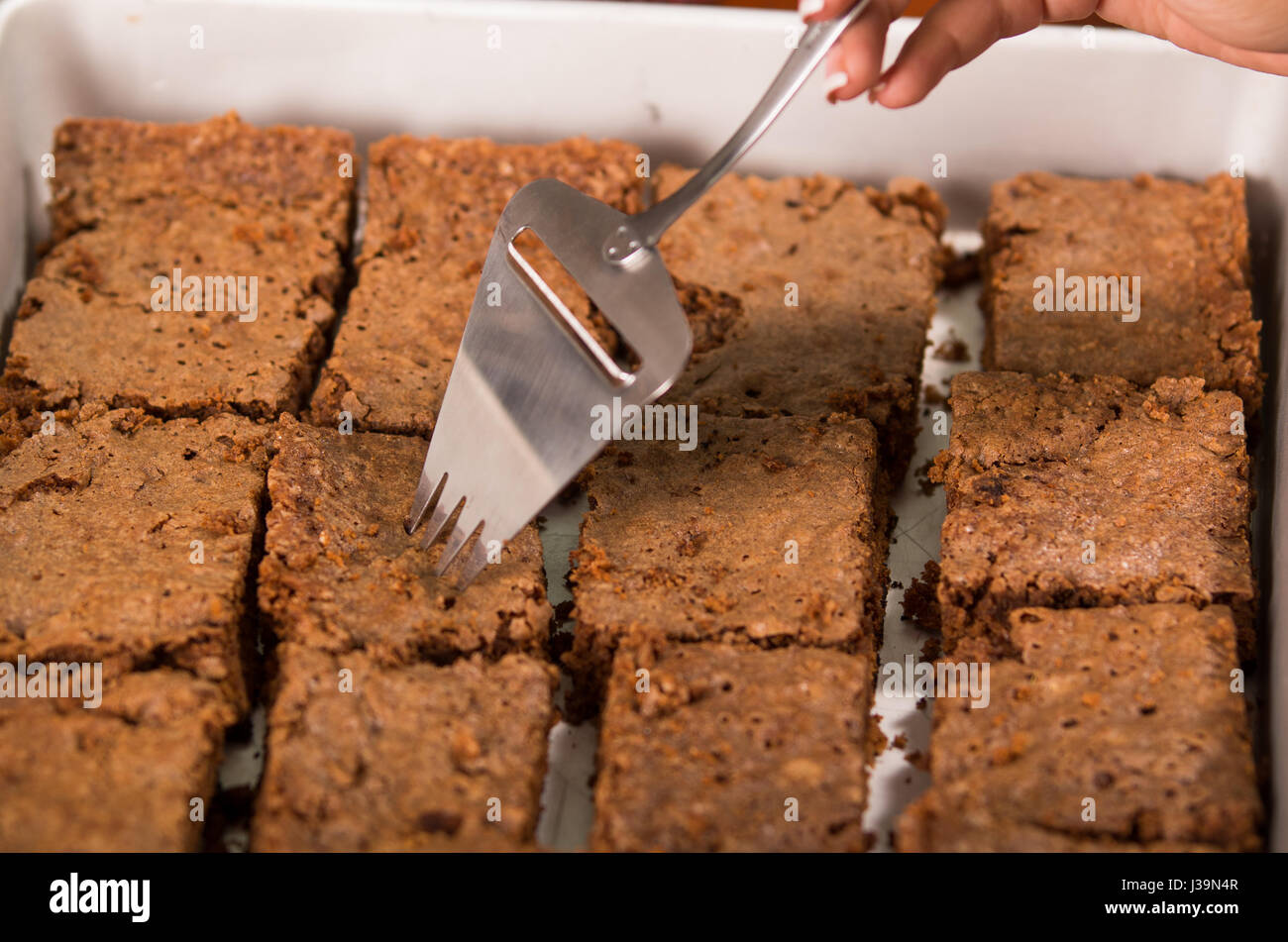 Köstlichen braunen farbigen Schokoladen-Brownies aufgereiht, quadratische Stücke wie gesehen von oben Winkel, Metall Kuchen Cutter verwendet, Gebäck-Konzept Stockfoto