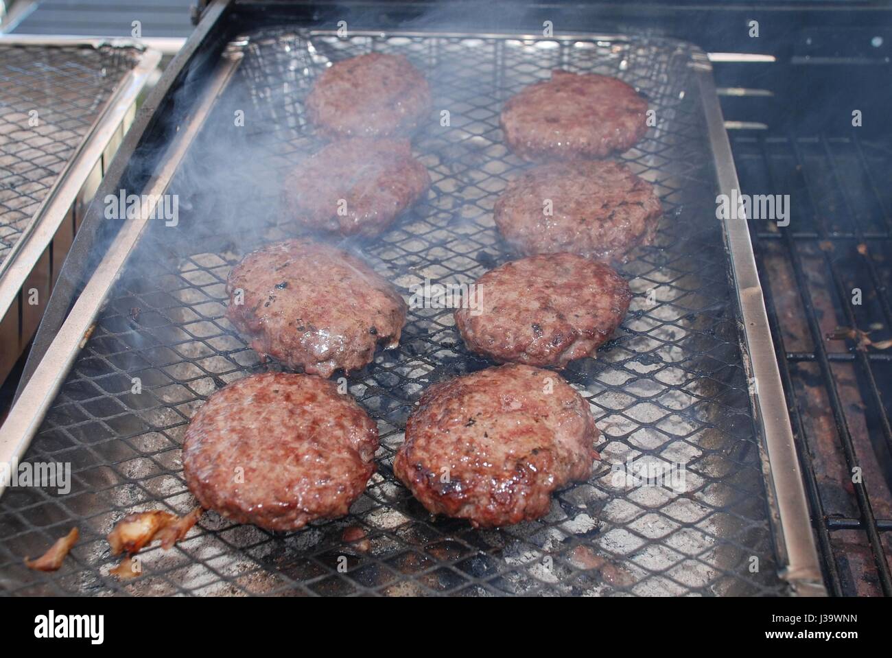 Burger Kochen auf einen Einweg-Grill in der Summer.in der UK Stockfoto