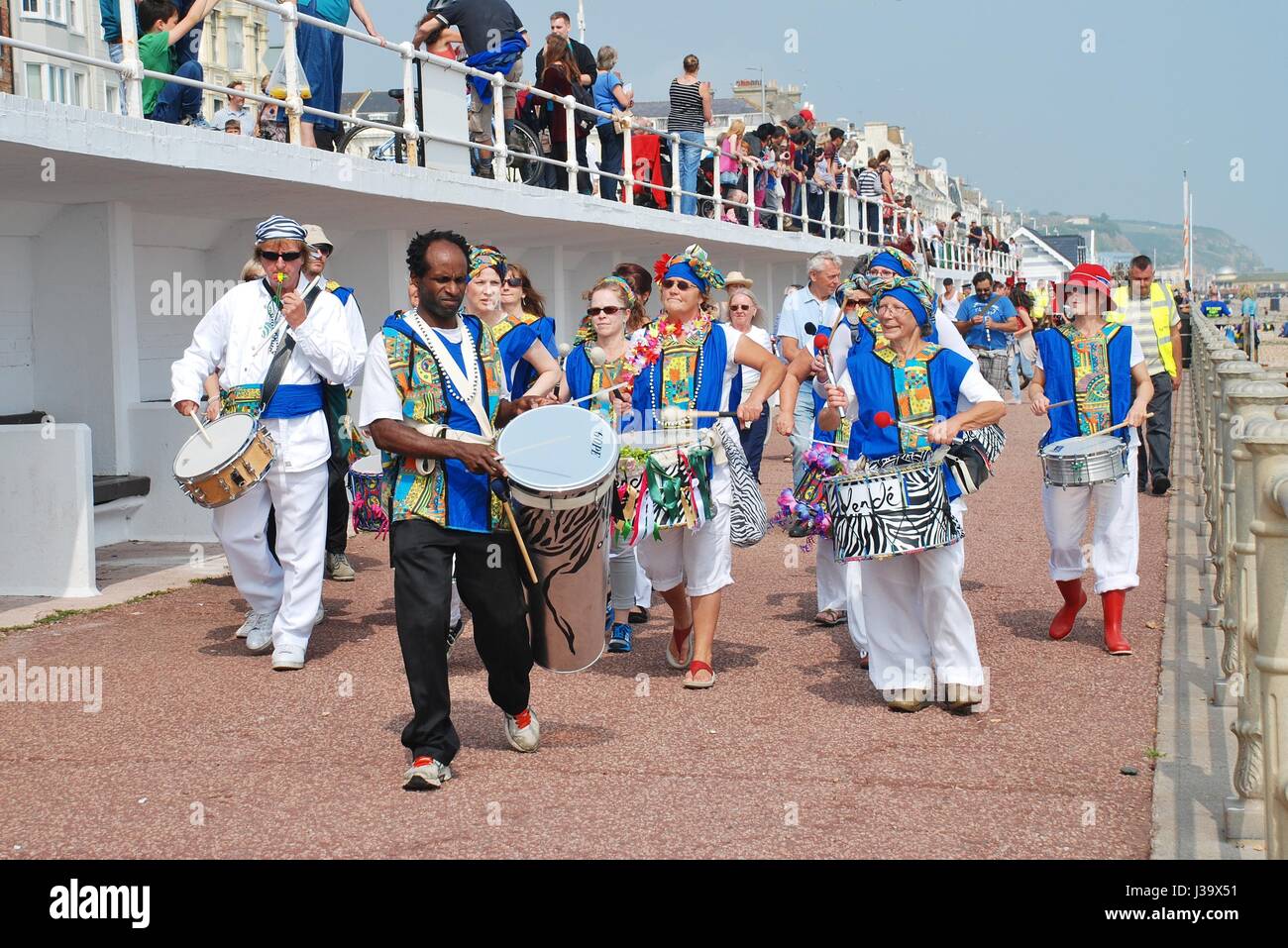 Samba-Band Dende Nation Parade entlang der Strandpromenade des jährlichen St.Leonards Festivals am St.Leonards-on-Sea, England am 12. Juli 2014. Stockfoto