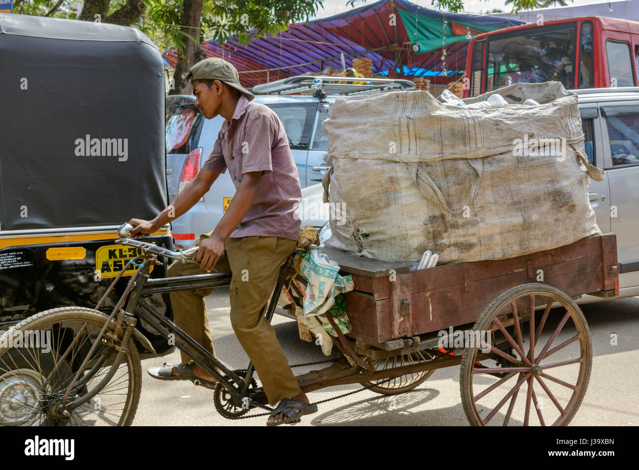 Ein Auslieferungsfahrer schlängelt sich durch den Verkehr mit seinem Velo-Rikscha in Alappuzha (Alleppey), Kerala, Südindien, Arthunkal, Südasien Stockfoto