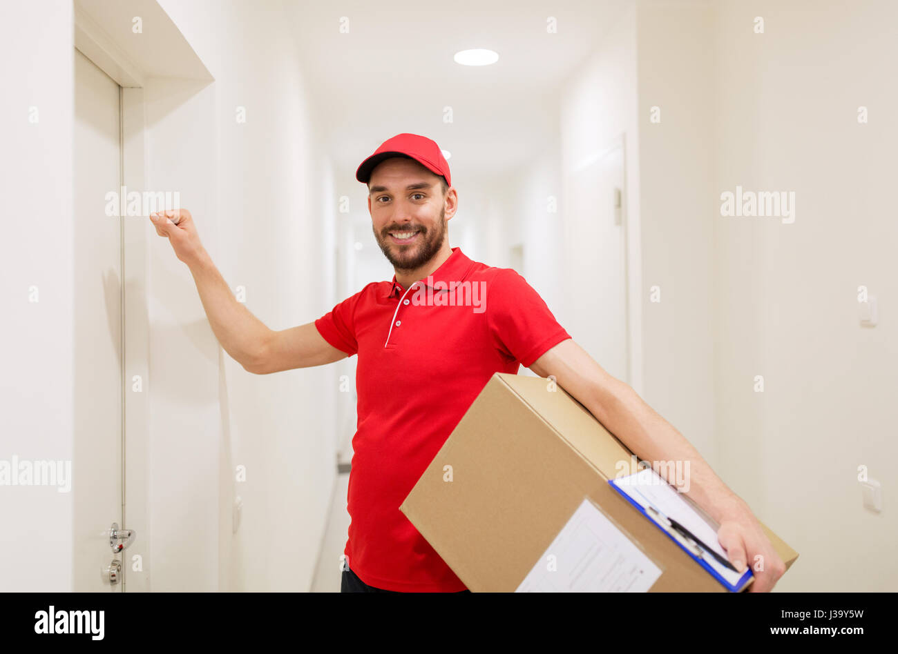 Lieferung Mann mit Paketbox klopfen an Tür Stockfoto