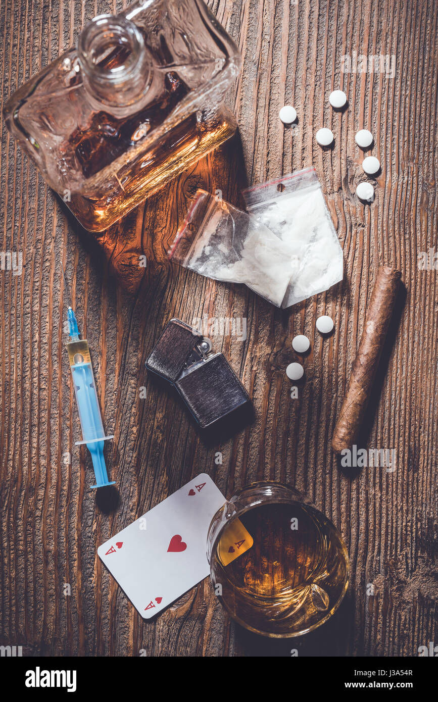 Sucht Konzept. Harte Drogen und Alkohol auf hölzernen Tisch Stockfoto
