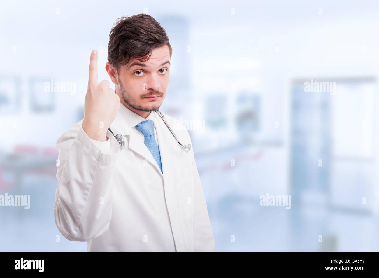 Jungen männlichen Arzt erhebt sich ein Finger oder deutete etwas oben mit Textfreiraum Stockfoto