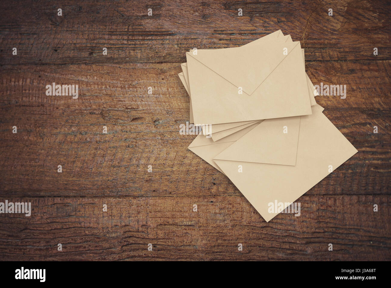 Briefumschläge für Post-Porto auf Holztisch Stockfoto