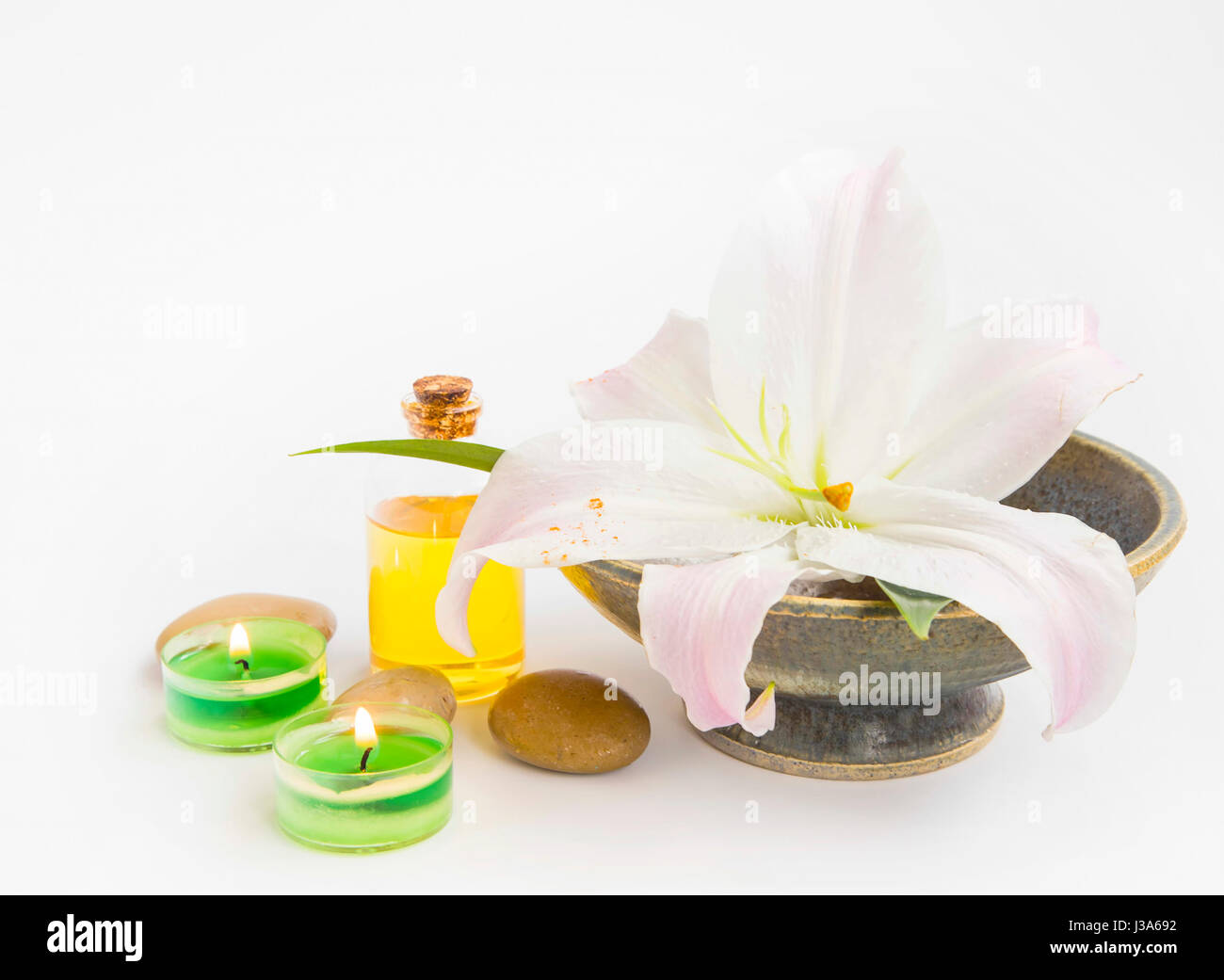 Spa-Stillleben-Einstellung mit Lilie, Kerzen, Öl-Flasche und massage-Steinen auf weiß, Textfreiraum Stockfoto