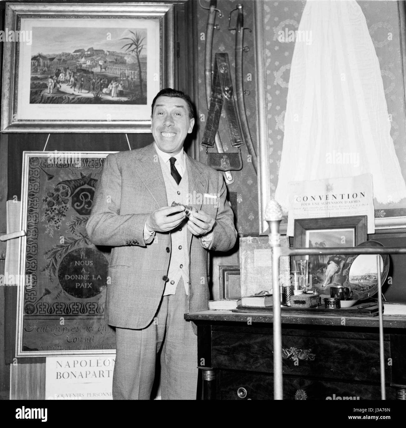 Französischer Schauspieler Fernandel posiert im Wohnzimmer des Fotografen Rétif De La Bretonne. c.1953 Stockfoto