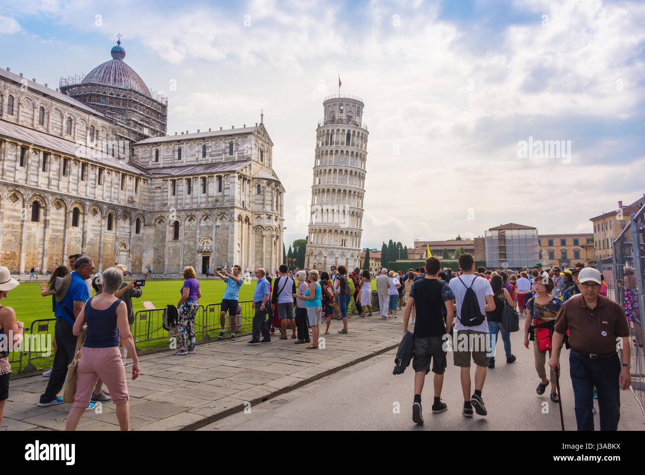 Pisa, Italien - 9. Juni 2016: Touristen versammeln sich auf dem Platz der Wunder in Pisa, der schiefe Turm von Pisa und die mittelalterliche Kathedrale des Bogens zu sehen Stockfoto