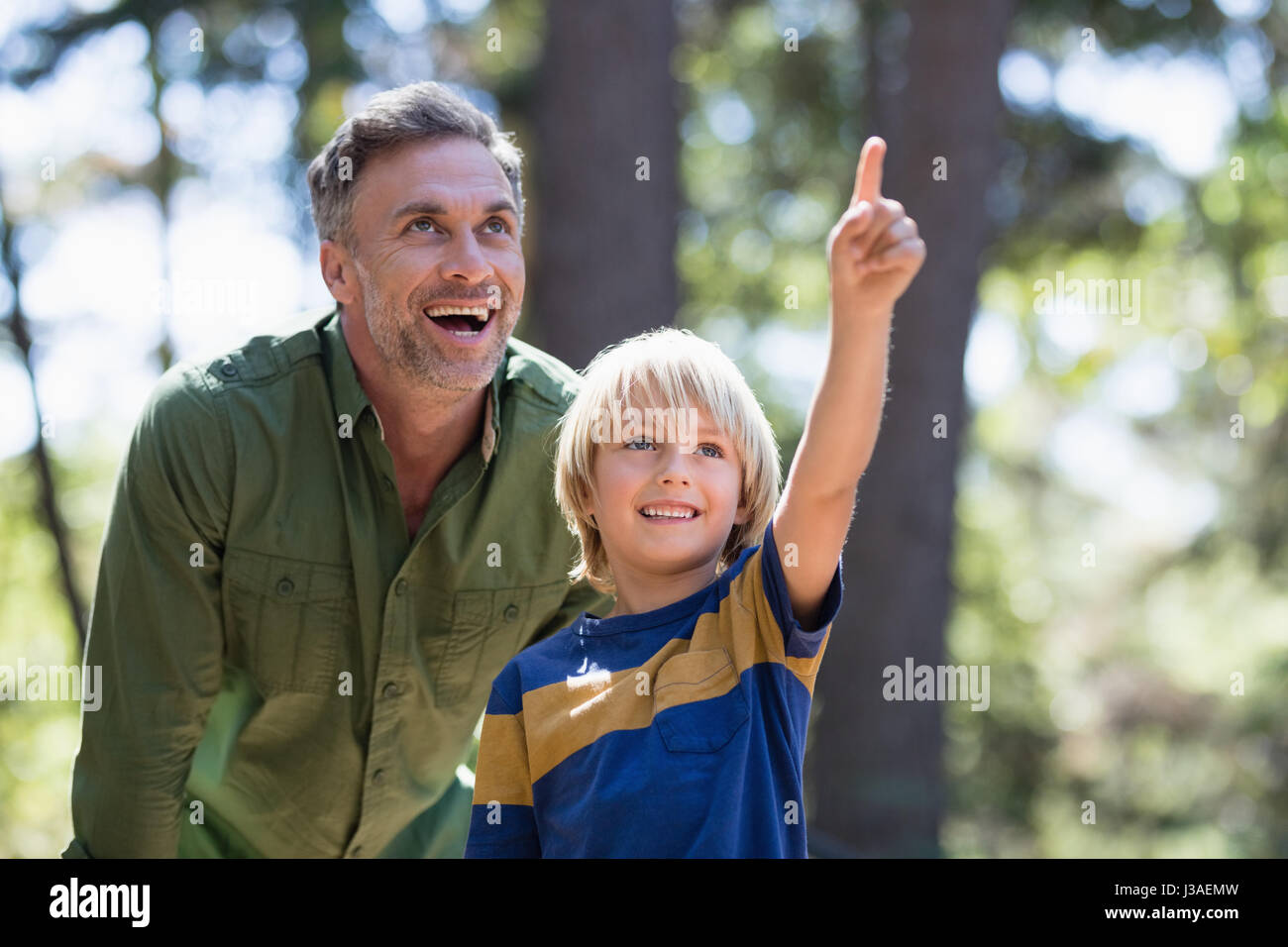 Kleiner Junge zeigt etwas zu fröhlich Vater beim Wandern im Wald Stockfoto