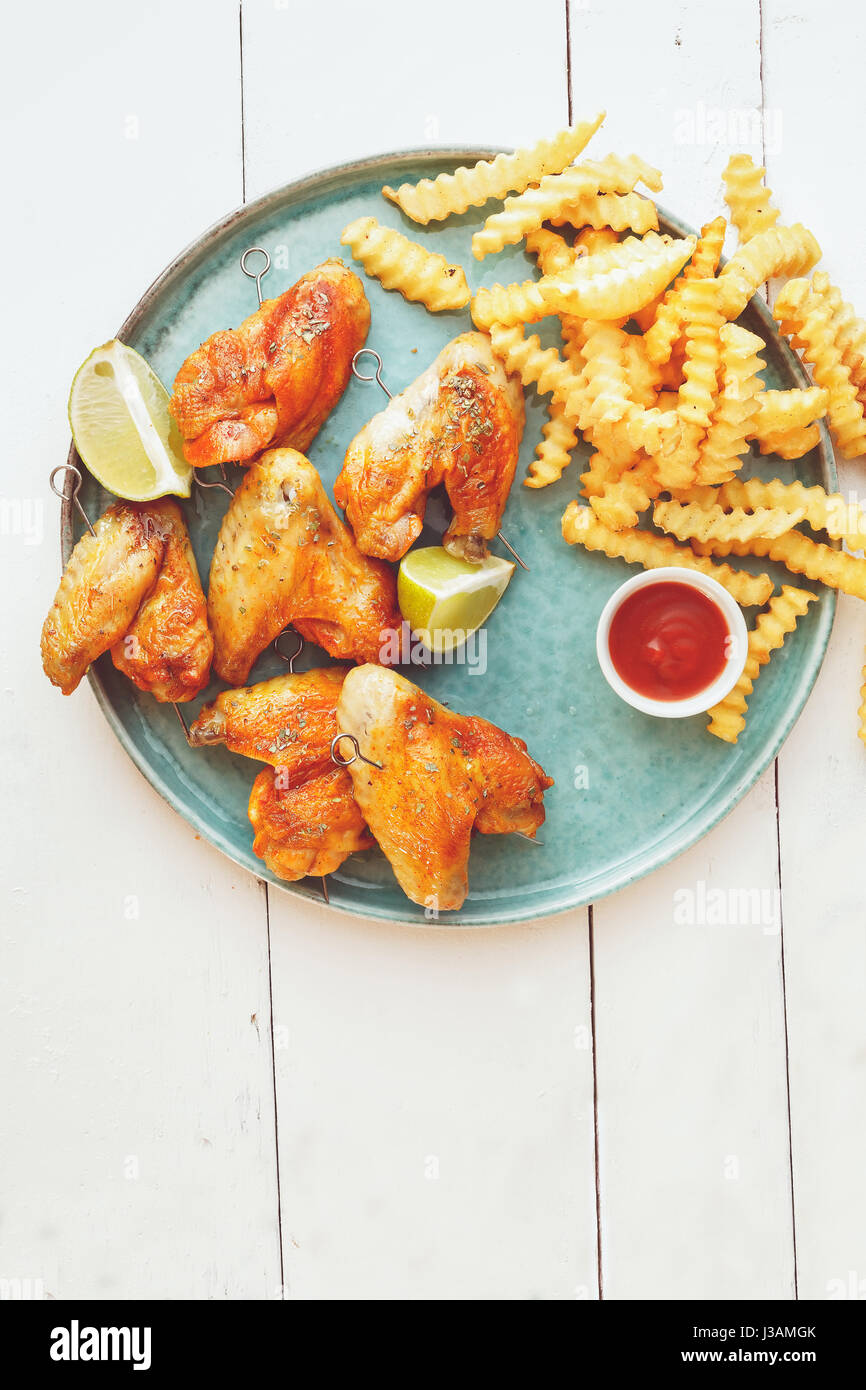 Gegrillte Hähnchenflügel mit Pommes Frites und Dip Saucen Draufsicht Textfreiraum Stockfoto