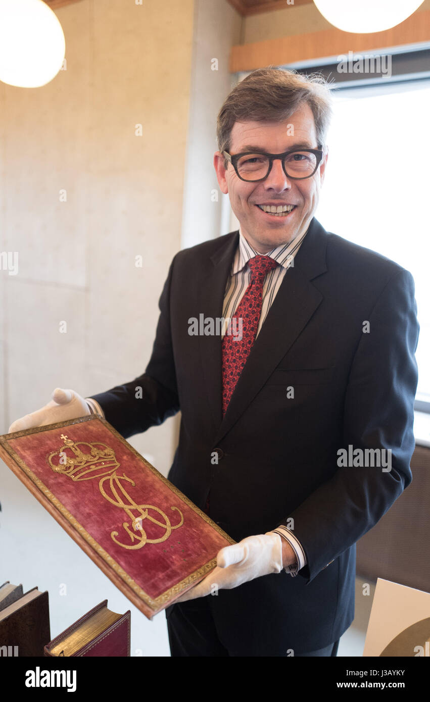 Holger Dorgerloh, Generaldirektor der Stiftung Preußischer Kulturbesitz präsentiert eines der Bücher von der "Prinzessin Bibliothek" in Berlin, Deutschland, 4. Mai 2017. Sie sind eine Hommage Schriften für Sophie Albertine. Die 4500 Volumen starke Sammlung von Sophie Dorothea von Hannover, Königin von Preußen (1712-1786), Luise Ulrike Preußen, Königin von Schweden (1720-1782) und Sophie Albertine, Prinzessin von Schweden (1753-1829) wurde von der Stiftung Preußische Schlösser und Gärten, mit Hilfe von fünf anderen Stiftungen und 120 Privatpersonen gekauft. Foto: Jörg Carstensen/dpa Stockfoto