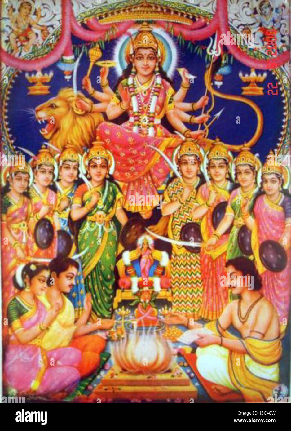 Dieses Kunstwerk zeigt Durga, die hinduistische Göttin, die einem vedischen Feueropfer vorsteht. Es ist ein Beispiel für die Basar-Kunst der 1950er Jahre, die die religiösen und kulturellen Traditionen der damaligen Zeit widerspiegelt. Stockfoto Dieses Kunstwerk zeigt Durga, die hinduistische Göttin, die einem vedischen Feueropfer vorsteht. Es ist ein Beispiel für die Basar-Kunst der 1950er Jahre, die die religiösen und kulturellen Traditionen der damaligen Zeit widerspiegelt. Stockfoto