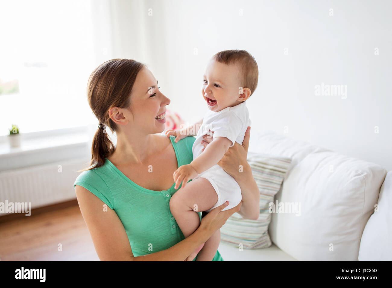 glückliche junge Mutter mit Baby zu Hause Stockfoto