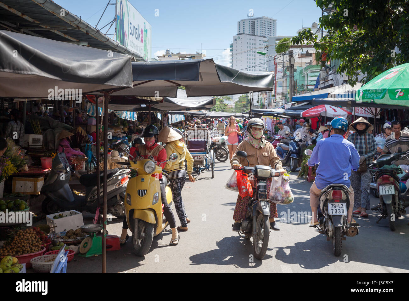 NHA TRANG, VIETNAM - Dezember 12: Frau mit Taschen für Einkäufe Motorrad auf dem nassen Markt 12. Dezember 2015 in Nha Trang, Vietnam reitet auf. Stockfoto