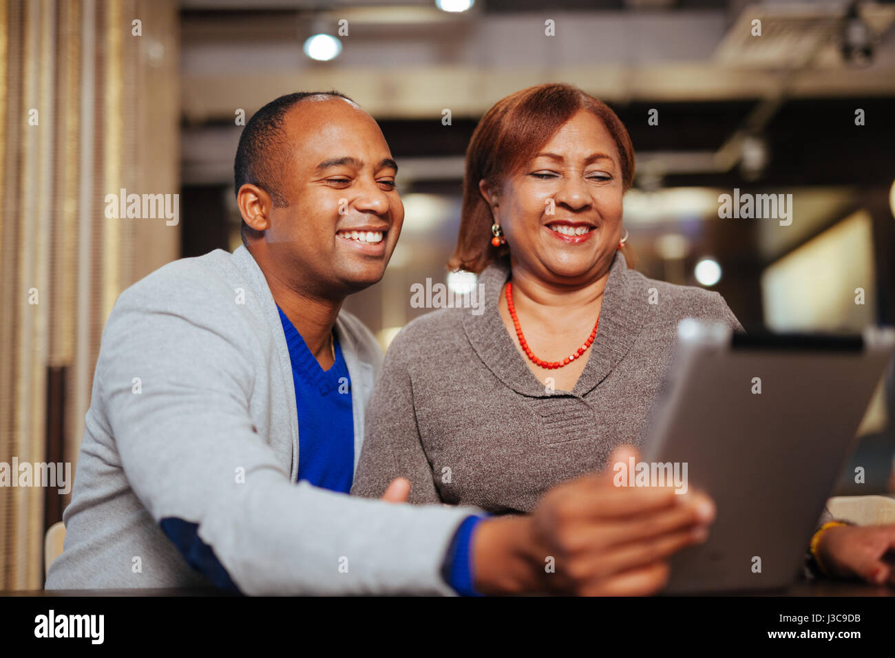 Mutter und Sohn halten ein Tablet Computer, mit Freunden reden Stockfoto
