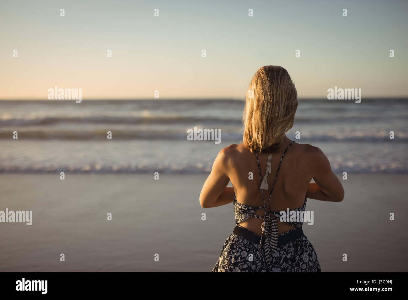 Rückansicht des Frau tun Yoga am Strand während der Dämmerung Stockfoto