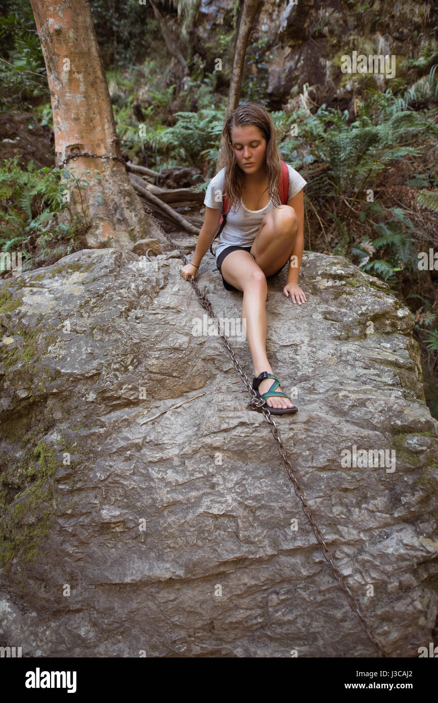 Bestimmt weibliche Wanderer hält die Kette beim Klettern auf den Felsen Stockfoto