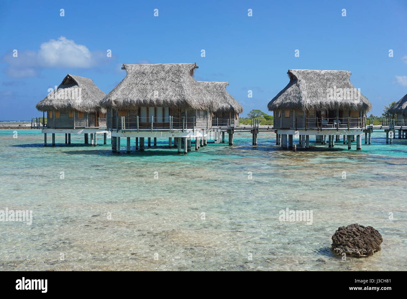 Tropische Lagune und Overwater Bungalows mit Strohdach, Atoll Tikehau, Tuamotu, Französisch-Polynesien, Süd-Pazifik Stockfoto