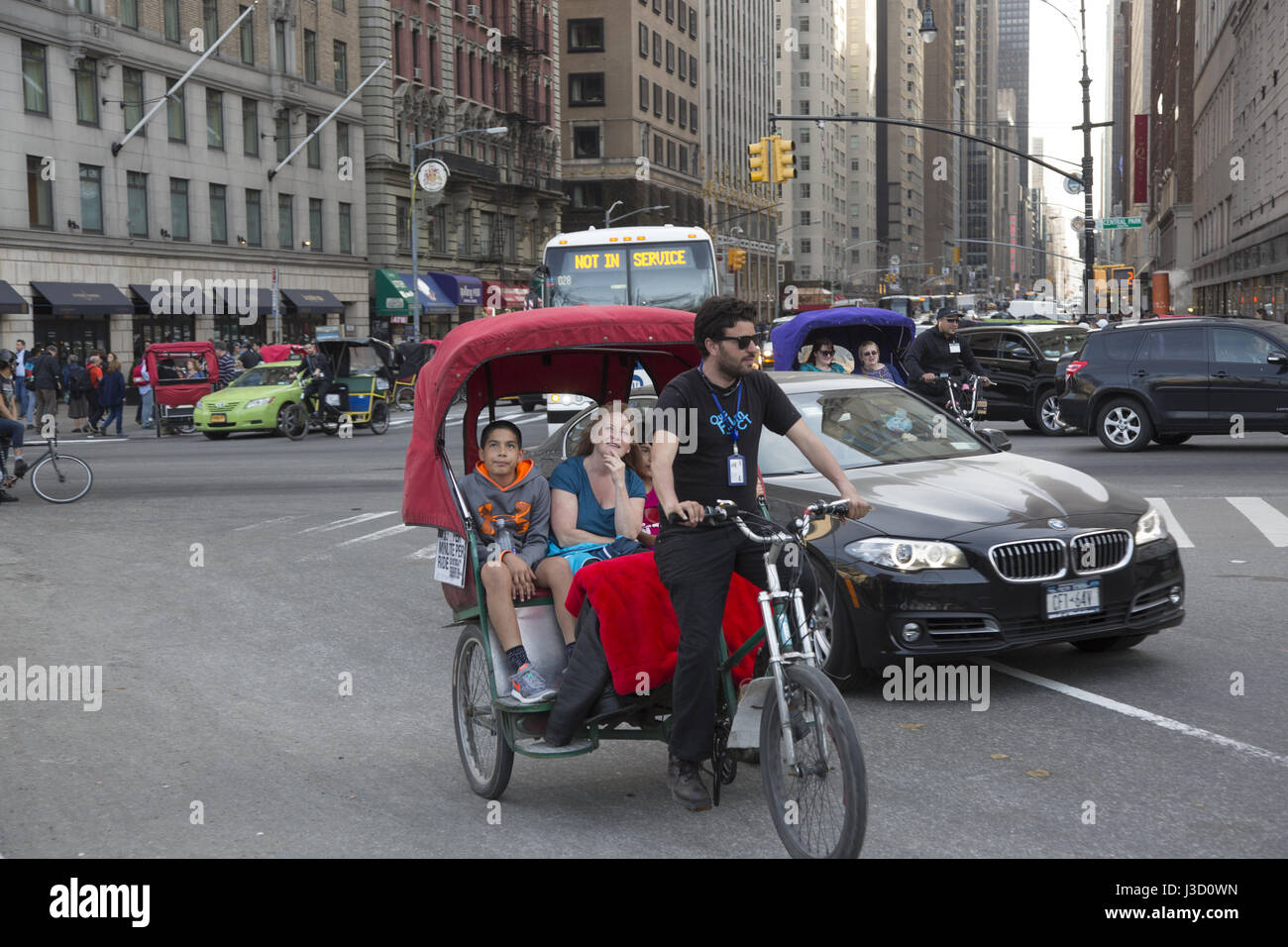 Rikscha mit Passagieren geht vom 6th Avenue in Manhattan, New York City Central Park. Stockfoto