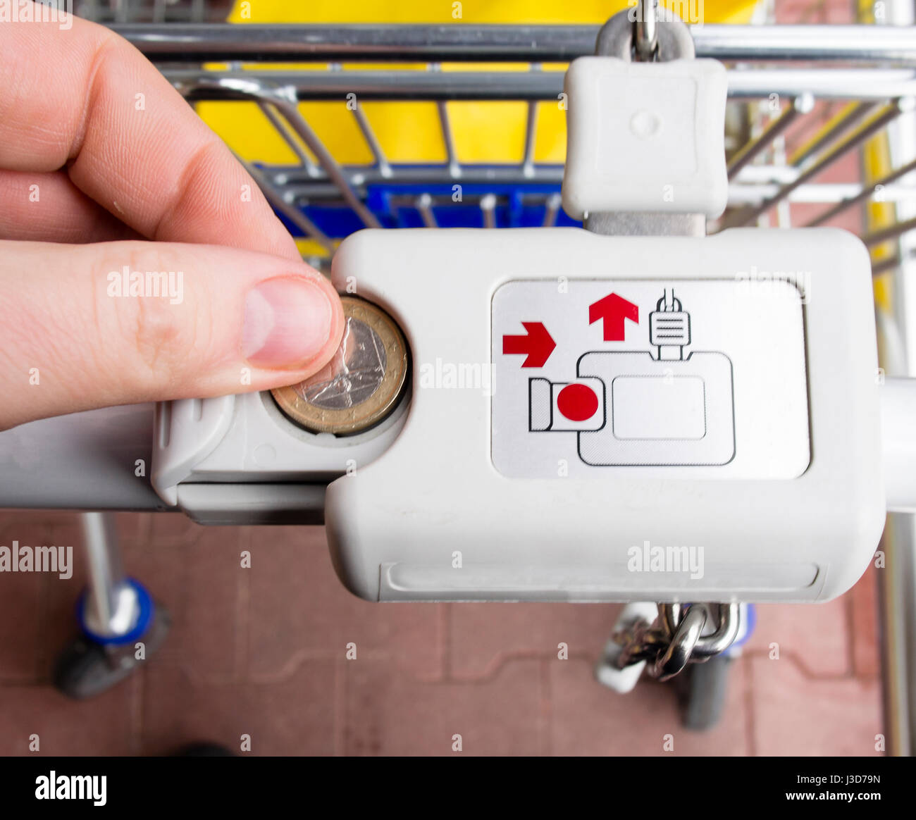 Hand des Mannes Entriegelung Lockeck Trolley im Supermarkt für Lebensmittel einkaufen Stockfoto