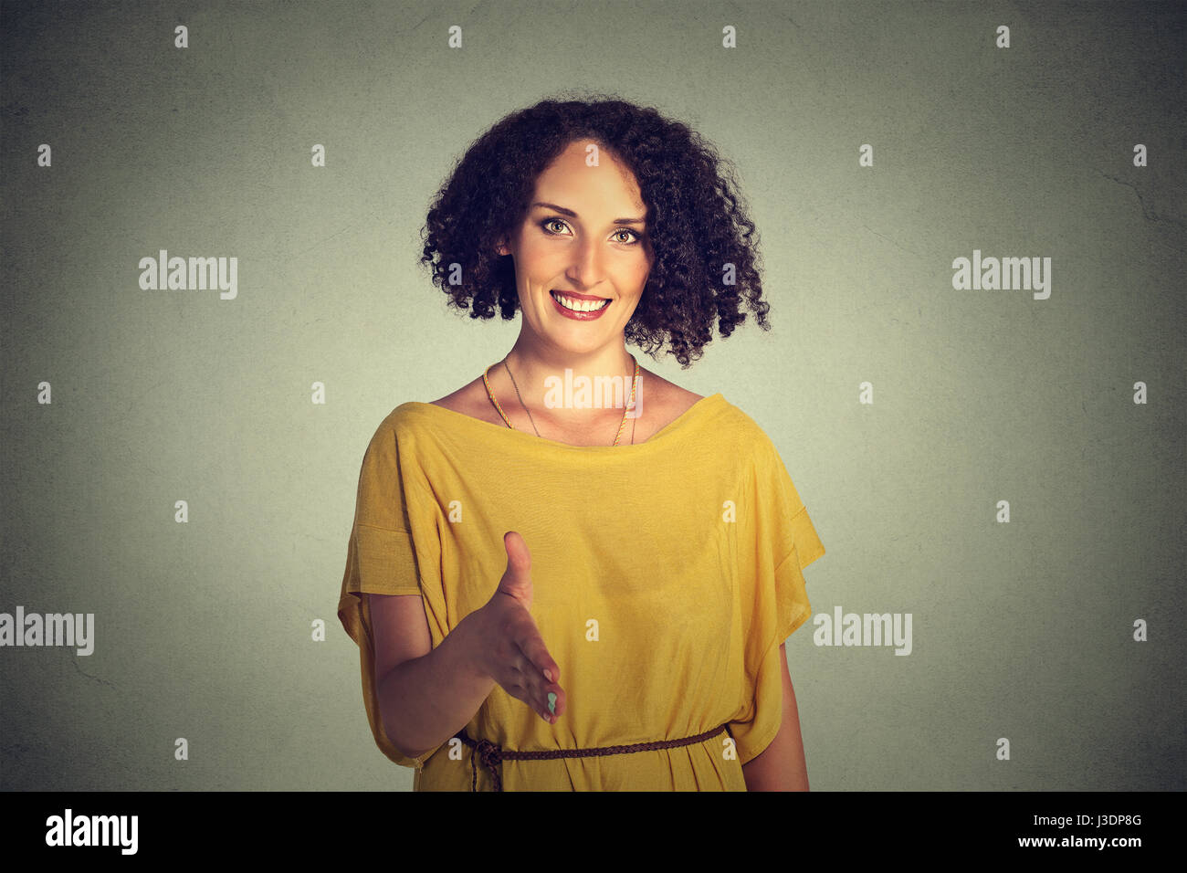 Closeup, Porträt, junge, lockiges Haar, Lächeln, Frau, Student, Kundenberater geben Ihnen Handshake auf graue Wand Hintergrund isoliert. Positiven hu Stockfoto