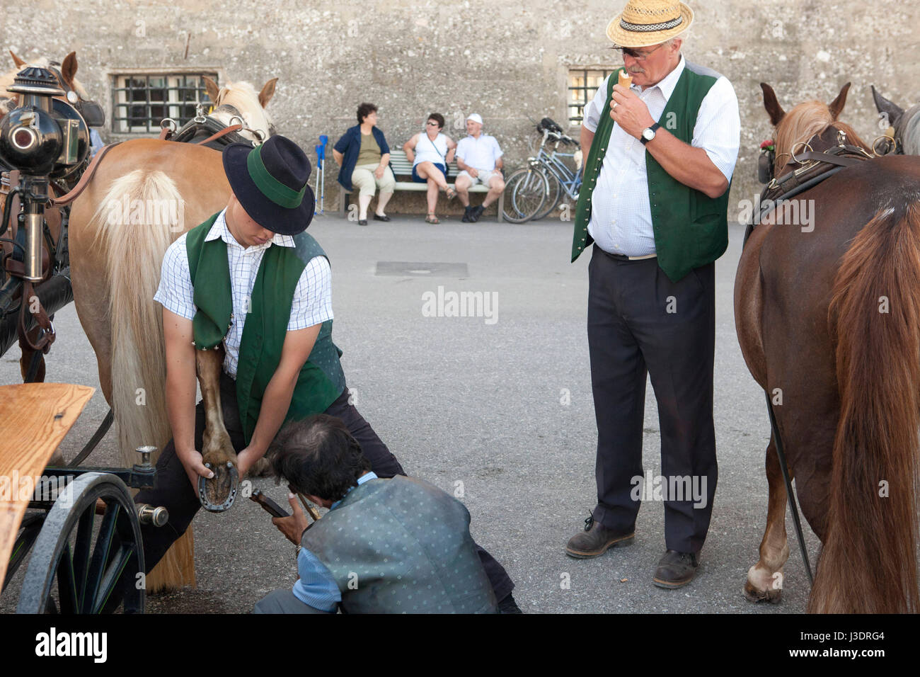 Zwei Männer reinigen den Huf eines Pferdes in Salzburg, Österreich Stockfoto